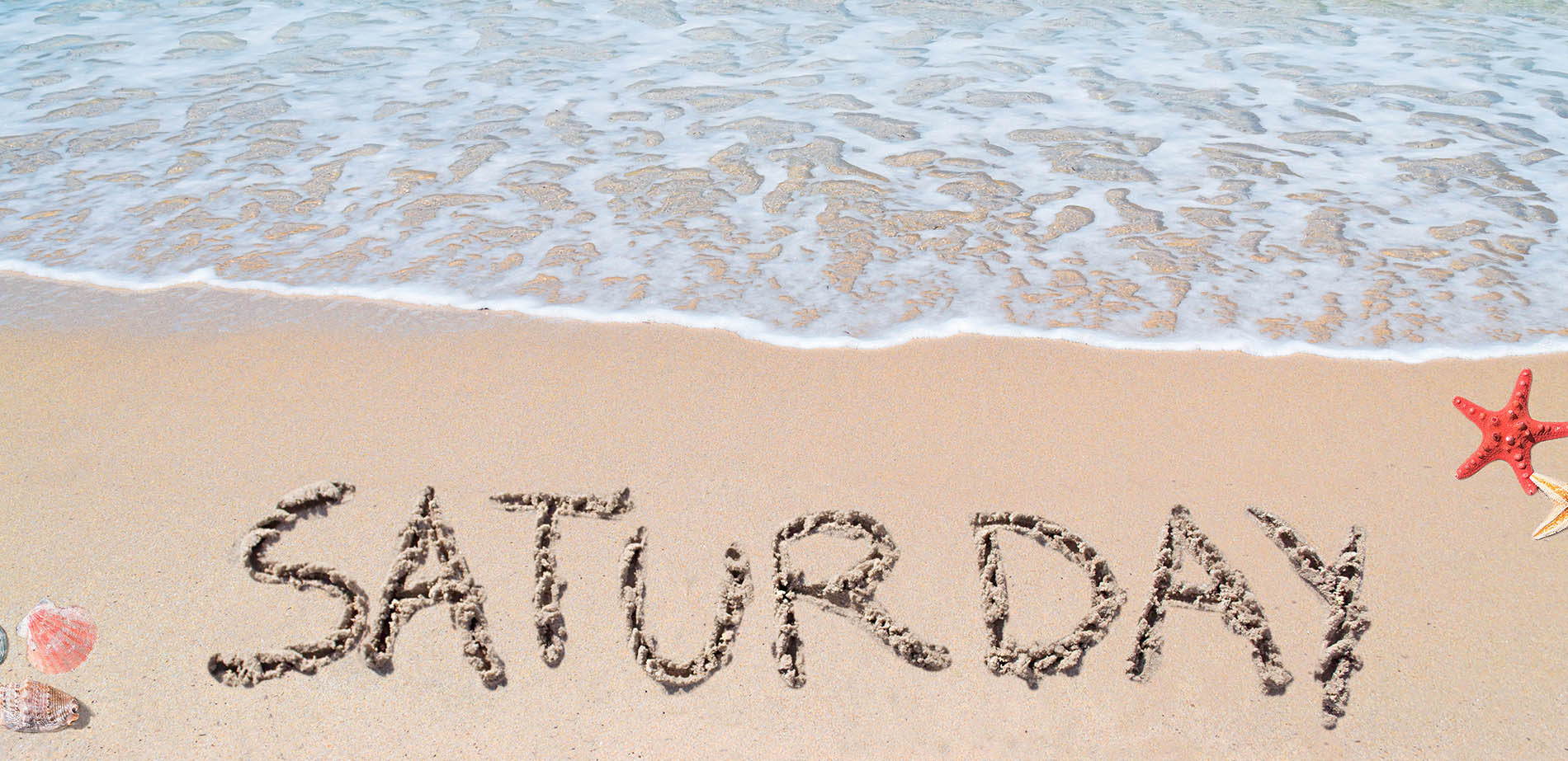 A beach scene with SATURDAY written in the sand
