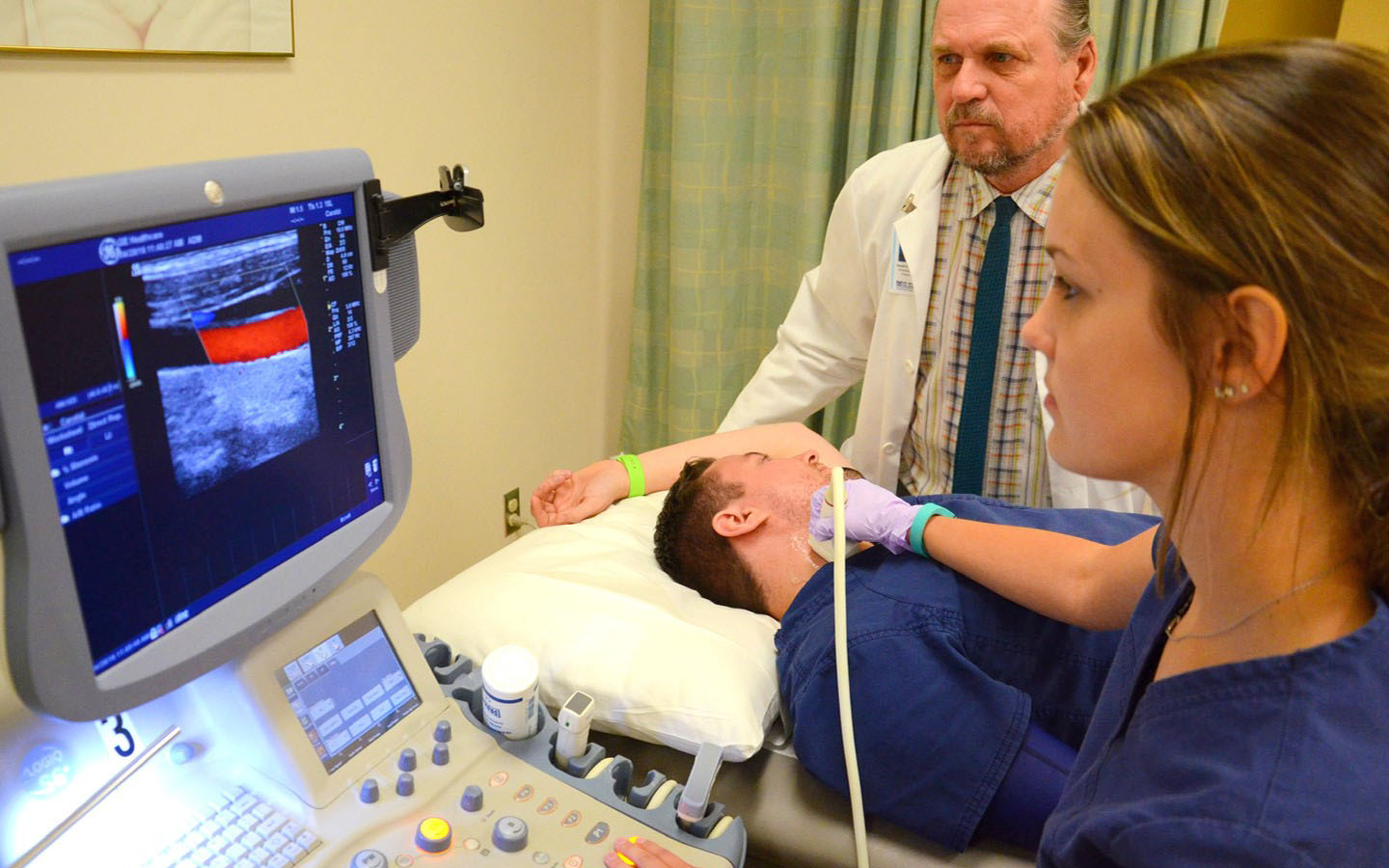 A student examines a patient in the lab.