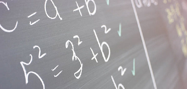 Various math problems written on a chalkboard.