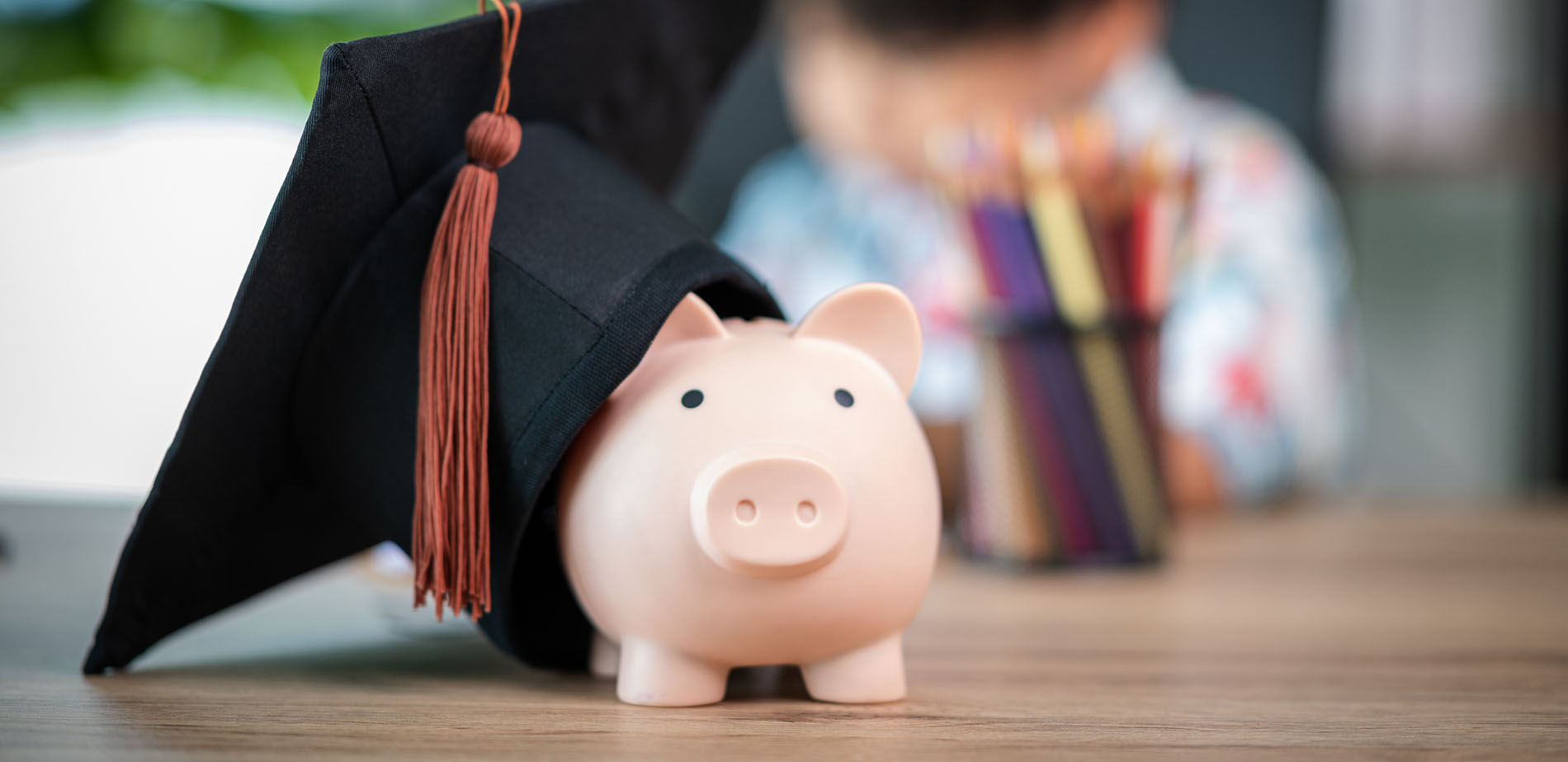 A piggy bank wearing a graduation cap