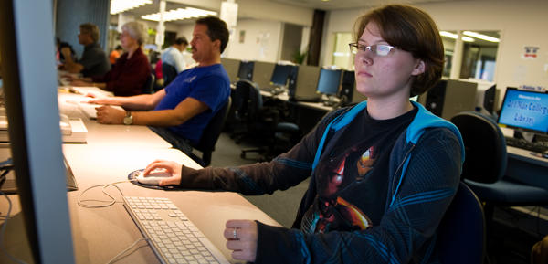 Students using computer with a serious face at the library.