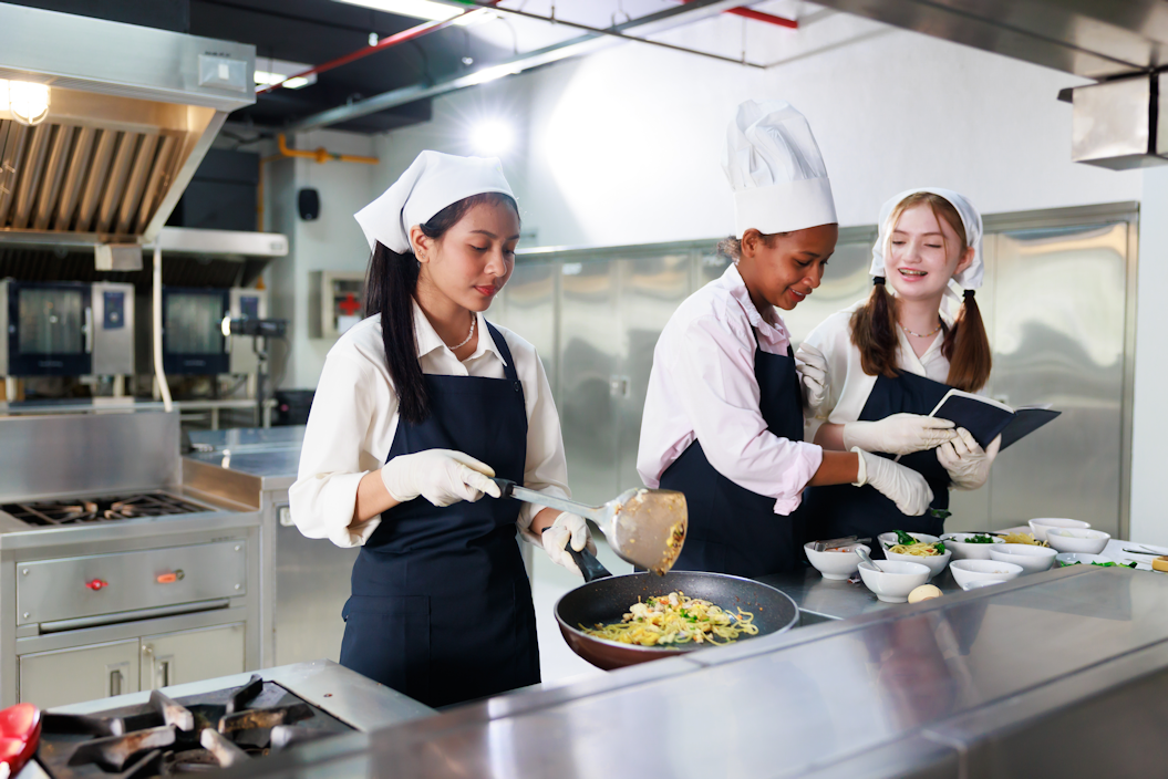 Three teens cooking in a chef's kitchen
