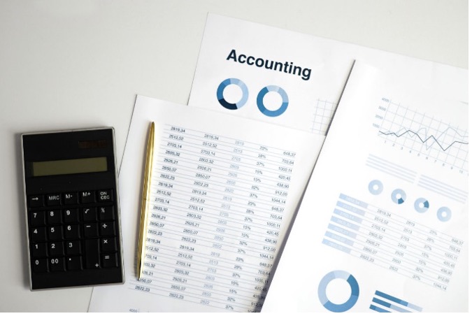 Overhead view of a calculator, pen, and accounting documents