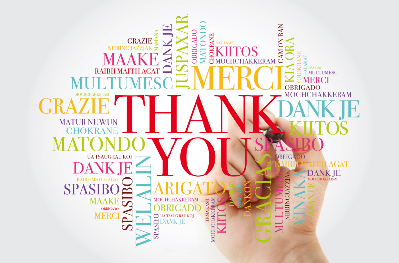A word cloud with "THANK YOU" in the center surrounded by translations in various languages and colors, with a hand holding a marker.