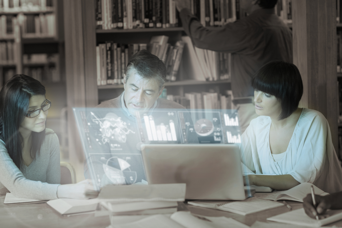 A group of people work together at a table inside the library.