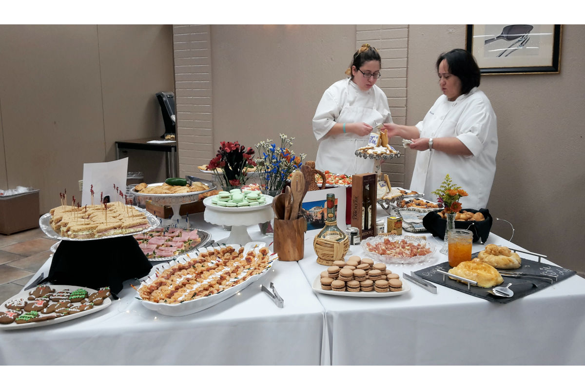 Chef Claudia and a baking students place baked goods for display