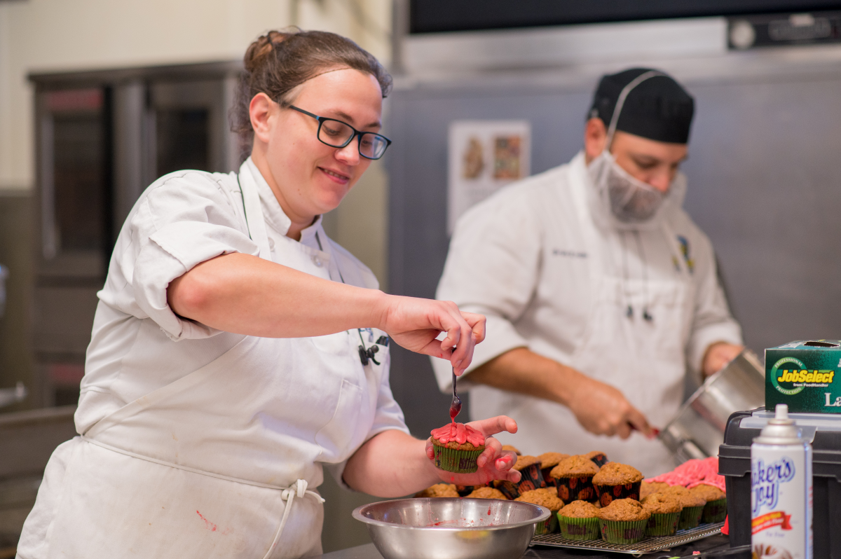 Two culinary students prepare food