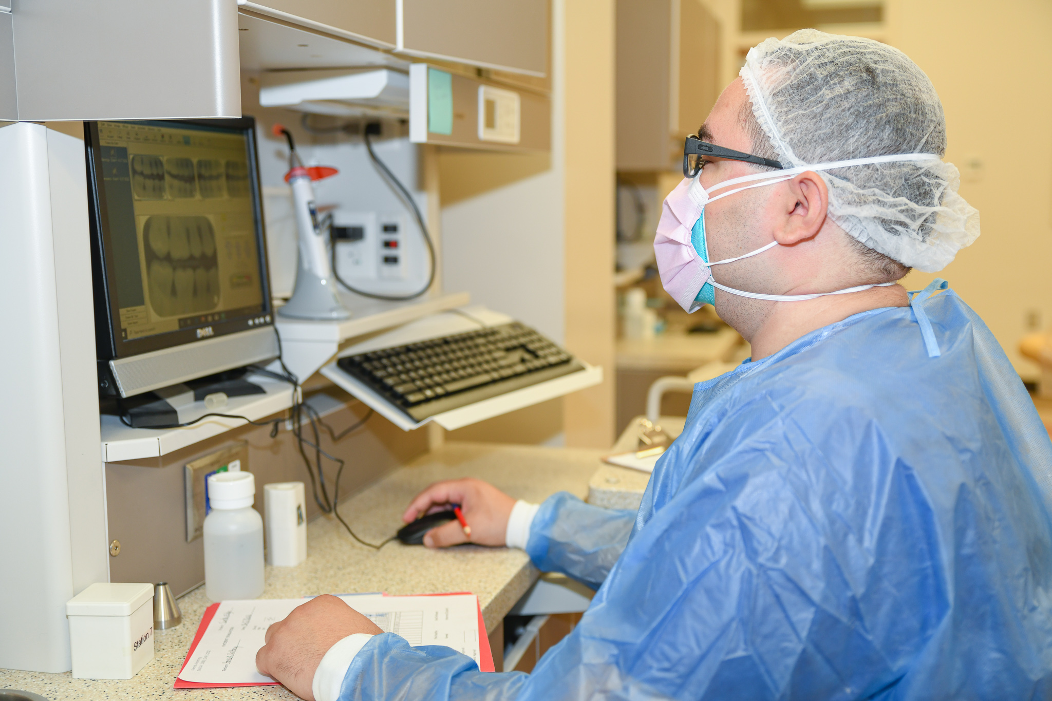 An instructor assists two students with dental procedure