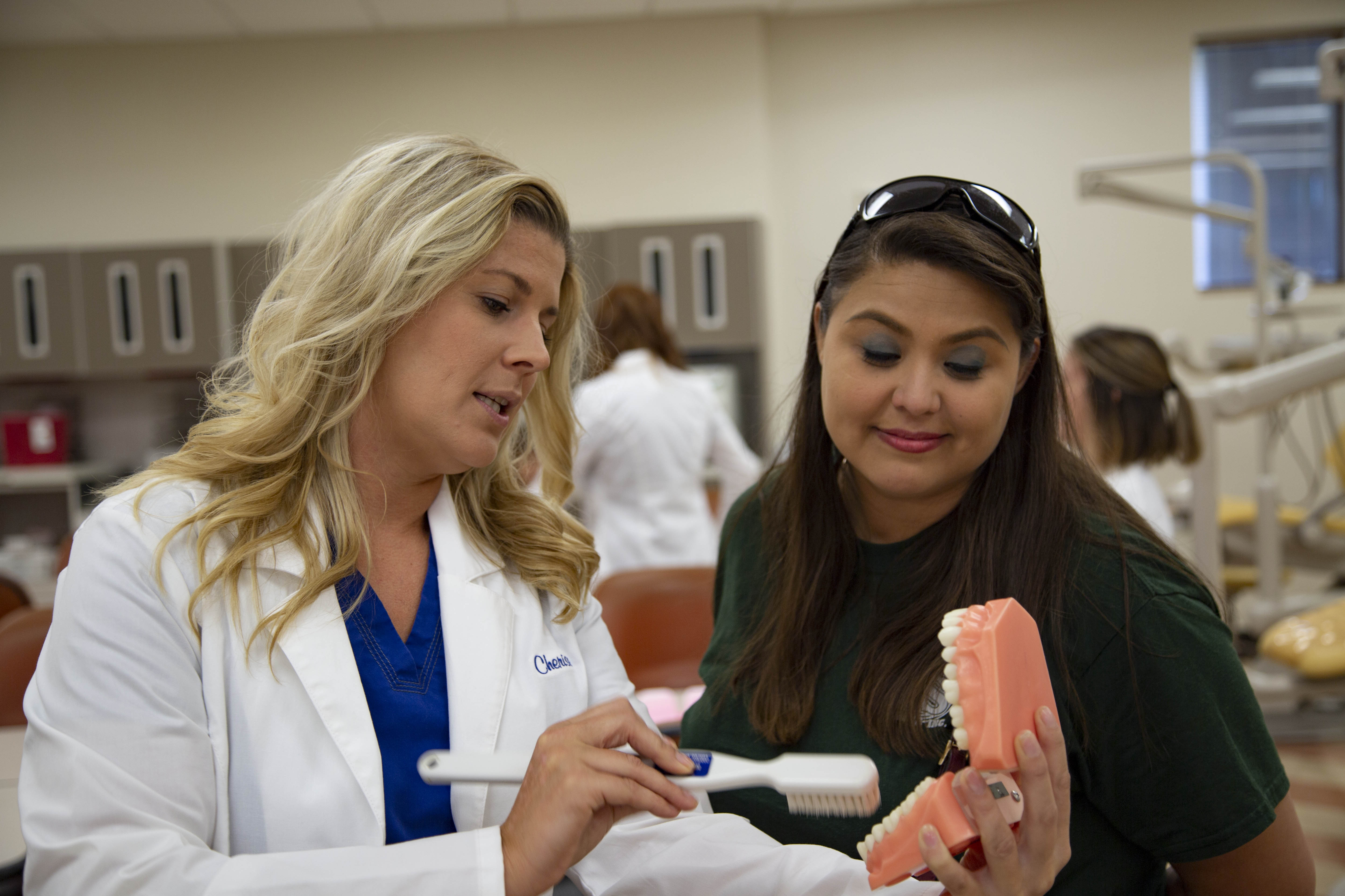 image of female dental hygiene student teaching dental health to another female