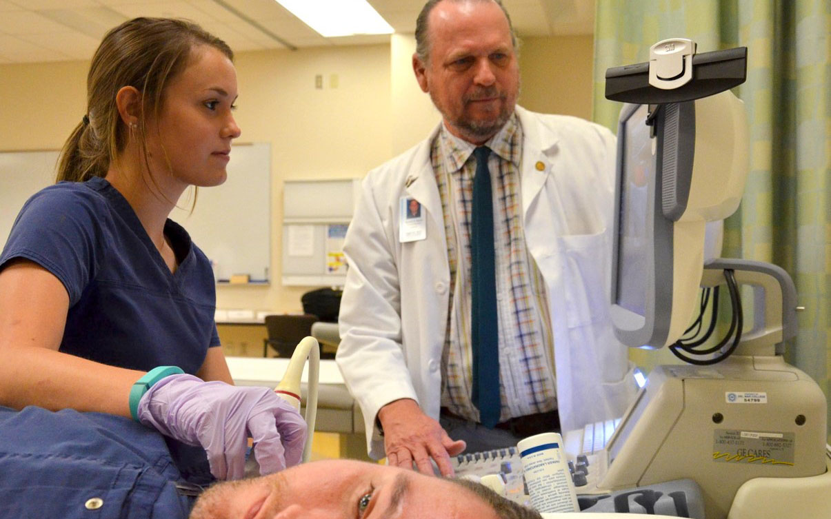 A student examines a patient in the lab.