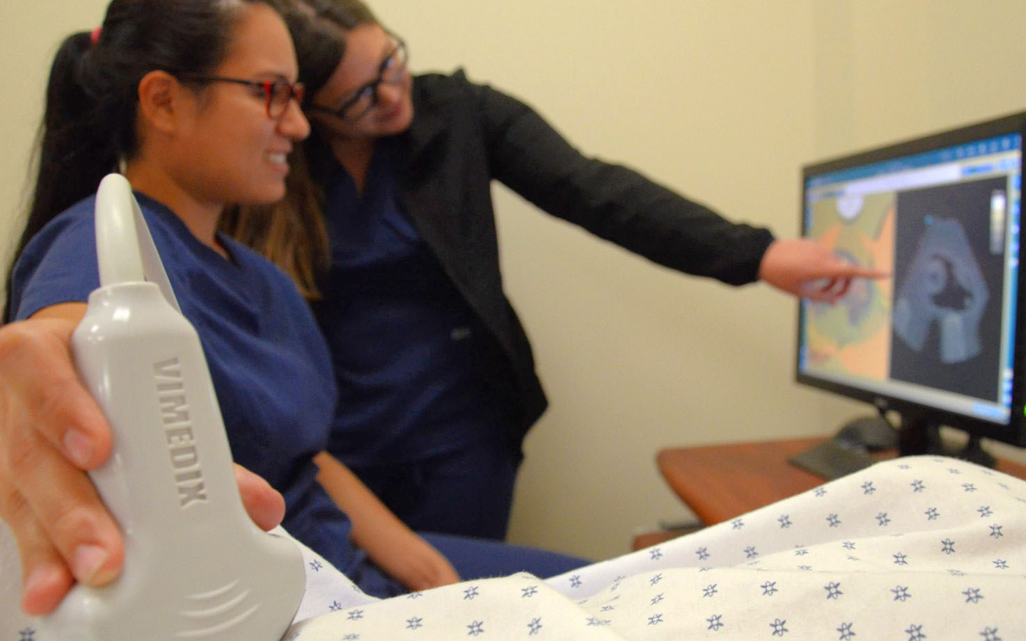 A student examines a patient in the lab.