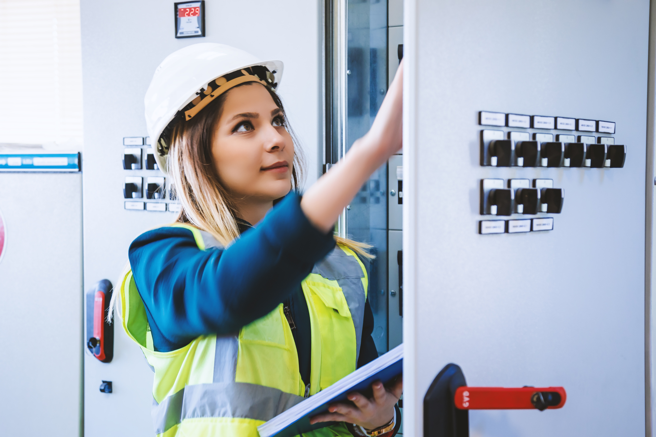 Blonde electrician wearing a hard hat.