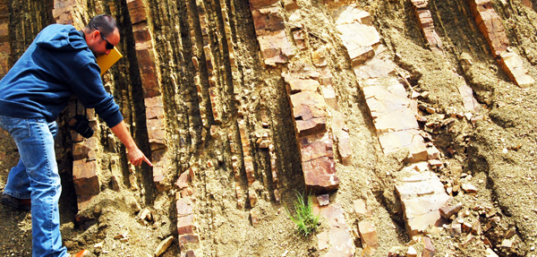 A geologist at the side of a mountain for examining.