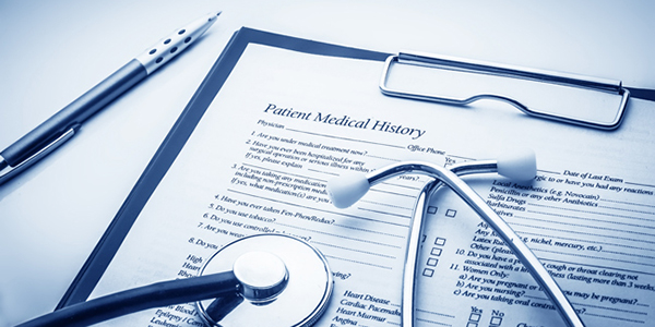 A stethoscope sits atop a clipboard holding a form titled Patient Medical History