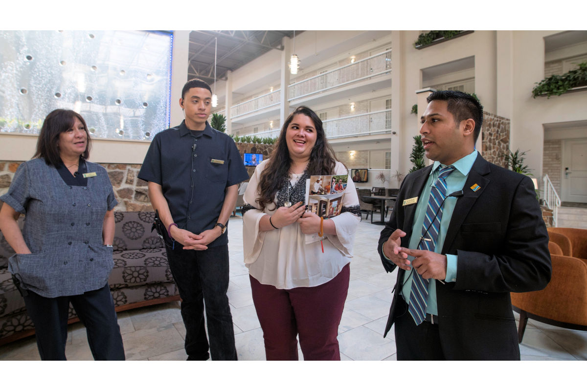 Hospitality students speak with employees at a hotel