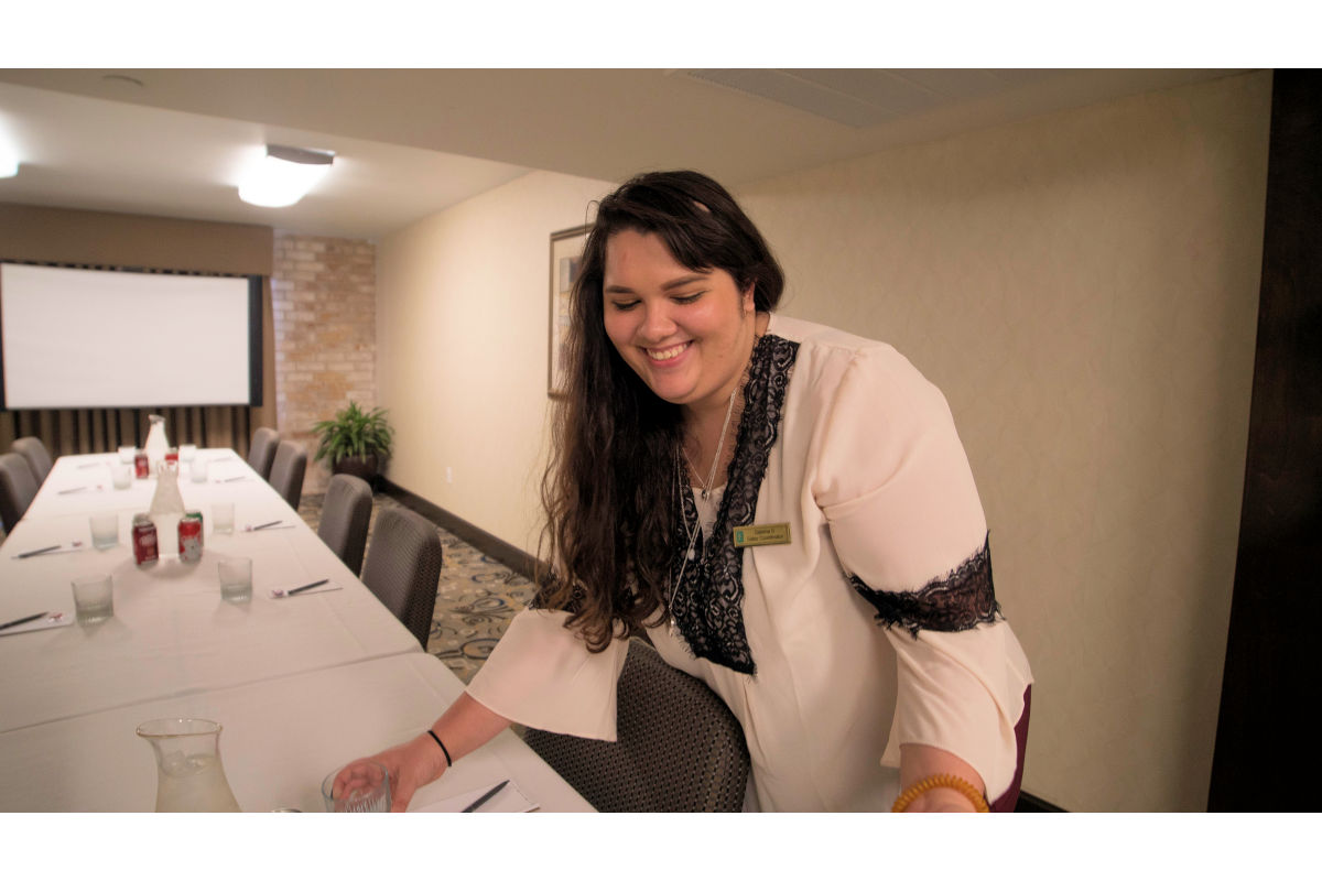 Female hospitality student arranges buffet table at a hotel