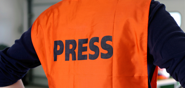 A man wearing a press vest.