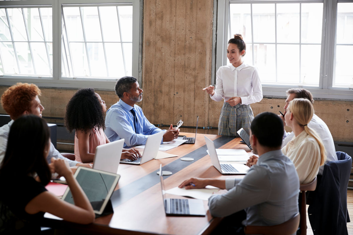 Business woman presents at a meeting of co-workers