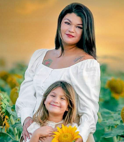 Aundrea Salinas Brasier and her daughter against a sunset backdrop.