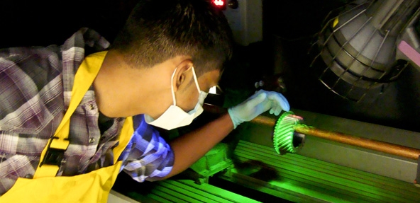 A student is working on a metal piece in a lab like environment.