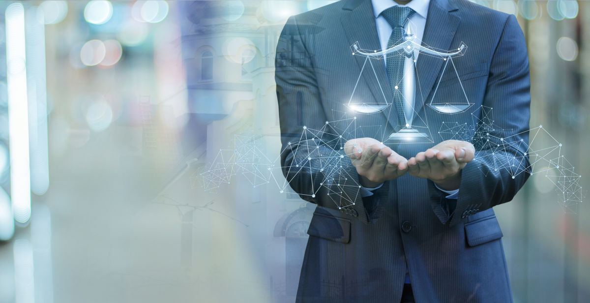 Photo of a lawyer in a suit holding a digital image of the scales of justice