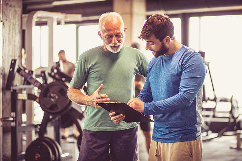Personal trainer working with an older client
