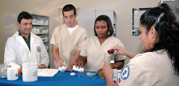 Various students mix together medicines in the lab.