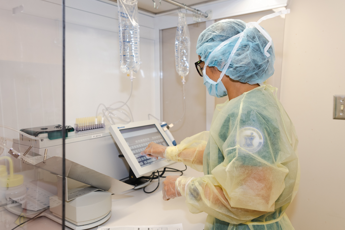 Pharmacy technician filling iv bags.