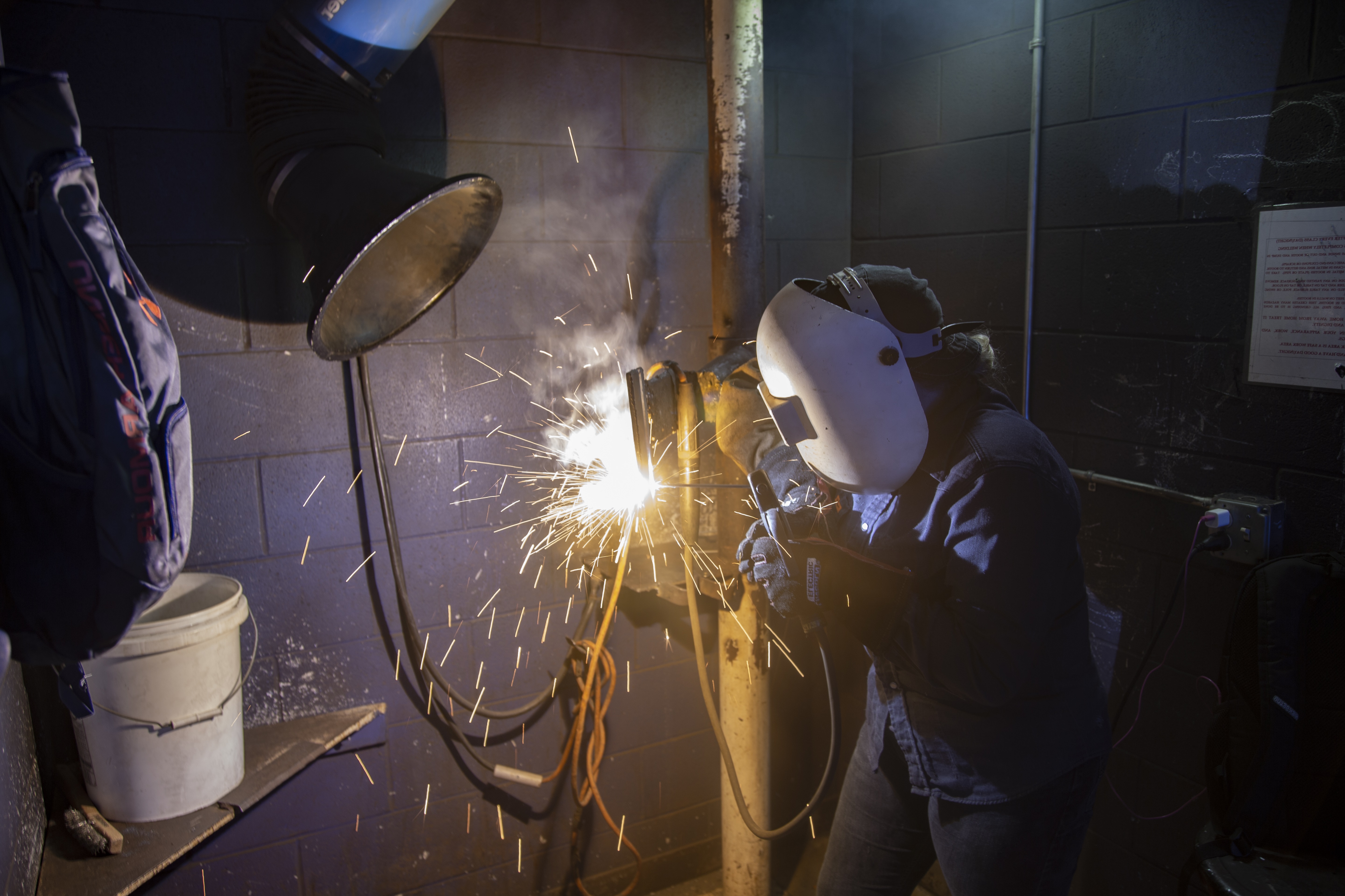 Woman welding with sparks flying