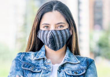 Female student with face mask standing outside