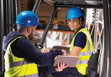 DMC student on heavy equipment interacting with instructor