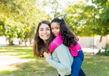 Mother and daughter happy with daughter on mother's back