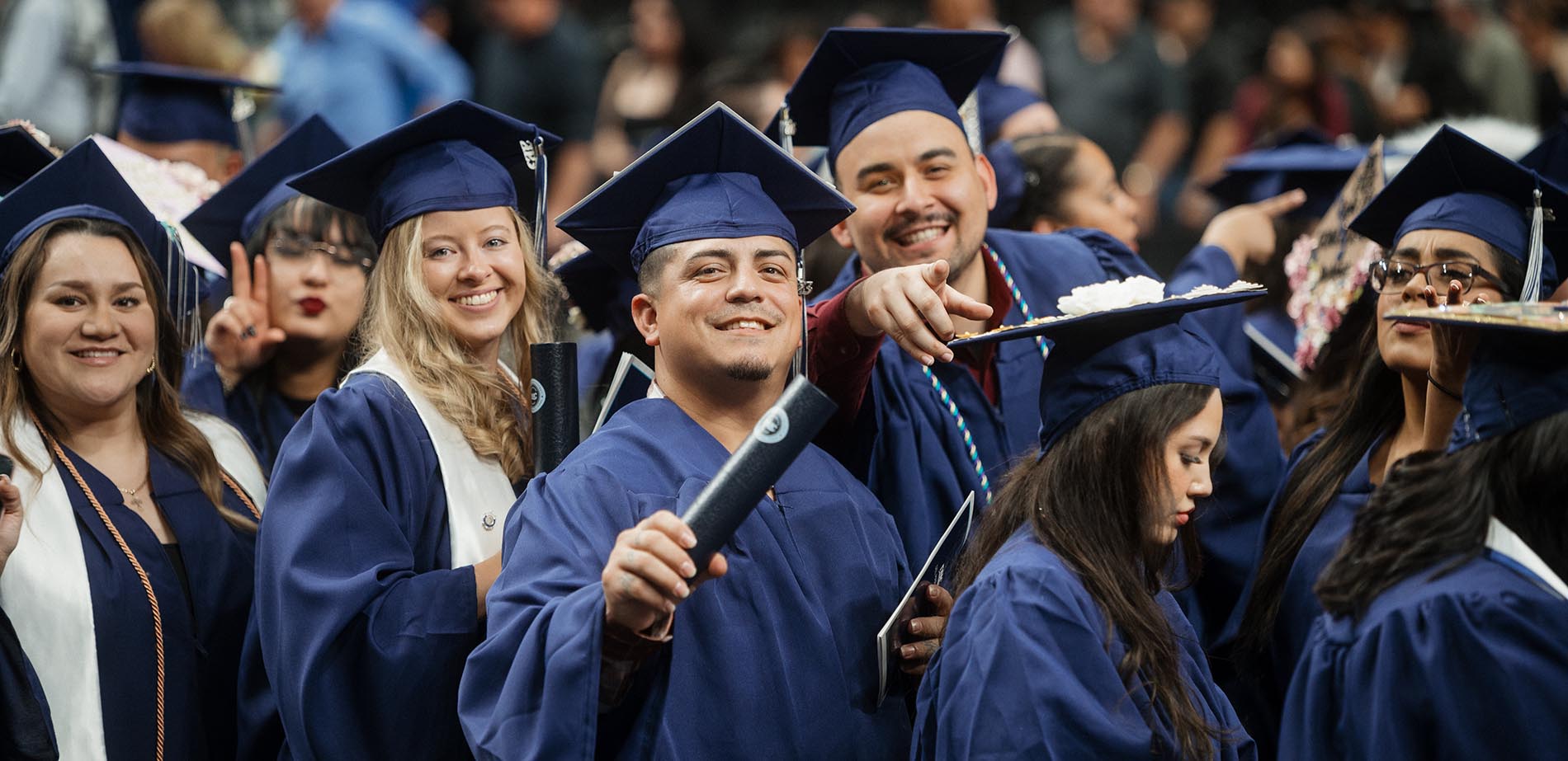 A group of graduates smiling and celebrating at graduation