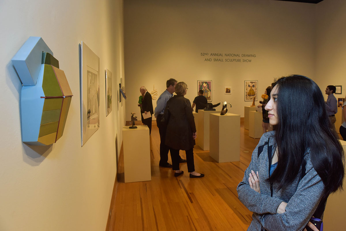 A visitor views a work of art in the Cain Gallery
