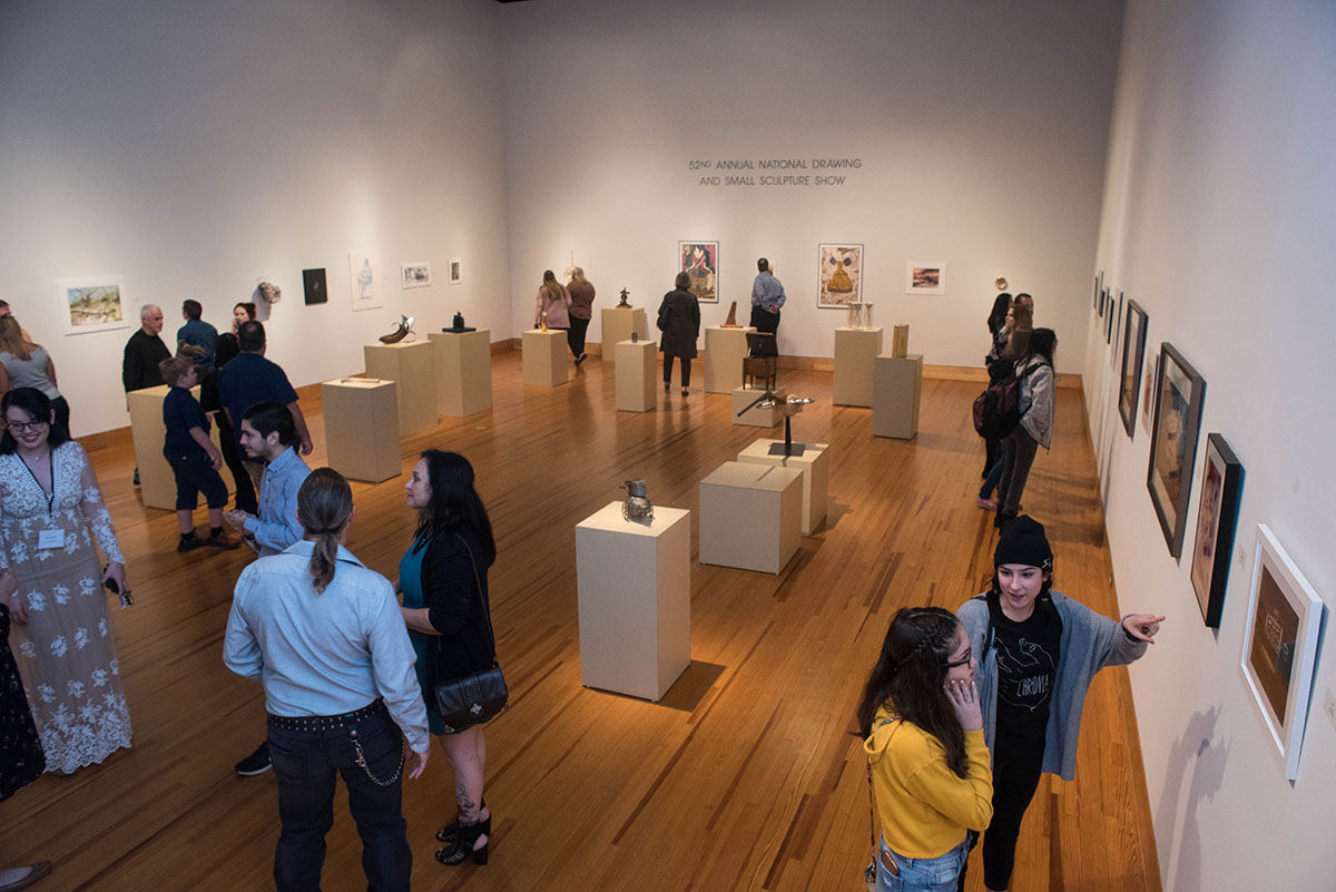 A small crowd views artwork in the Cain Gallery