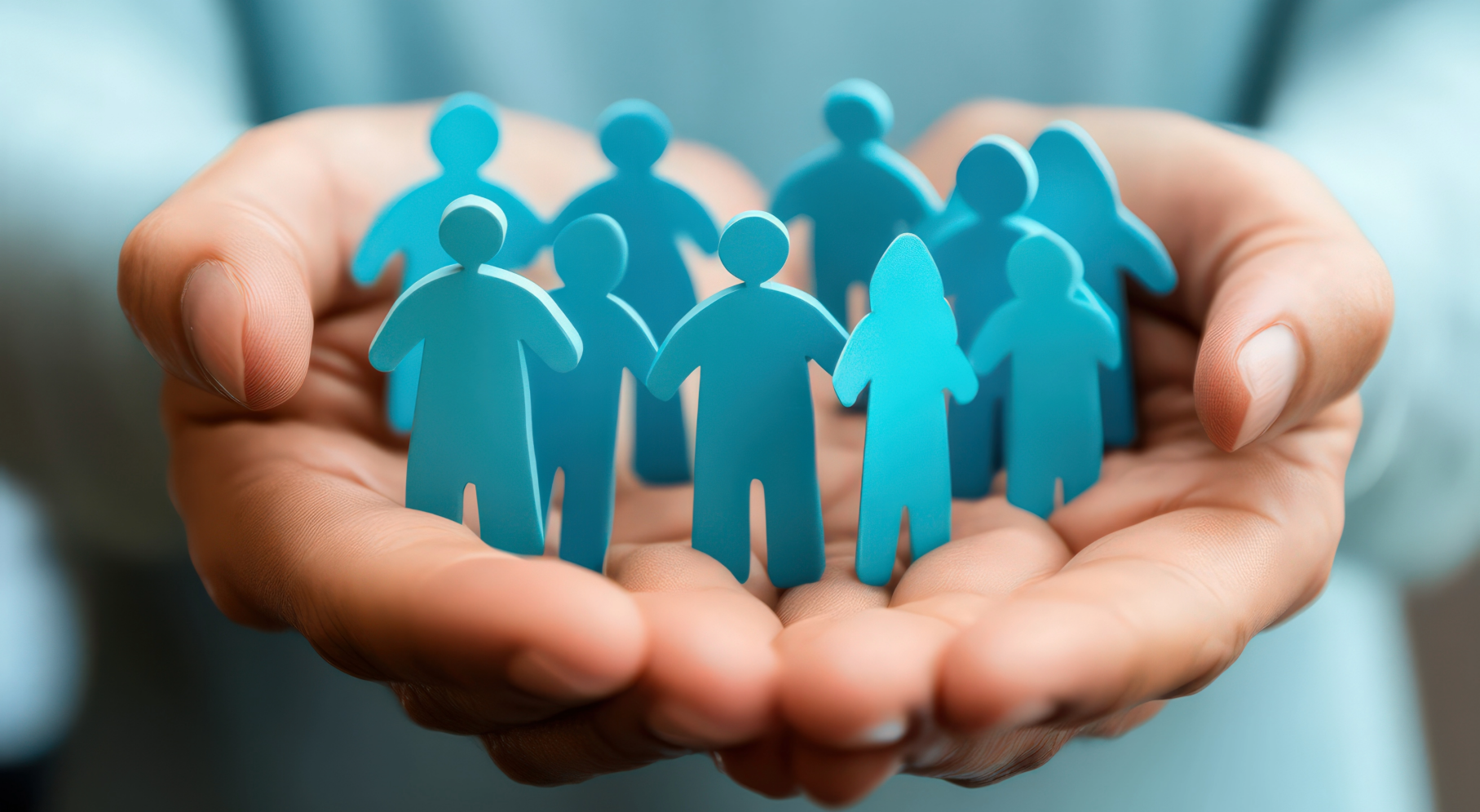 Hands holding cut-out dolls of several people in a circle