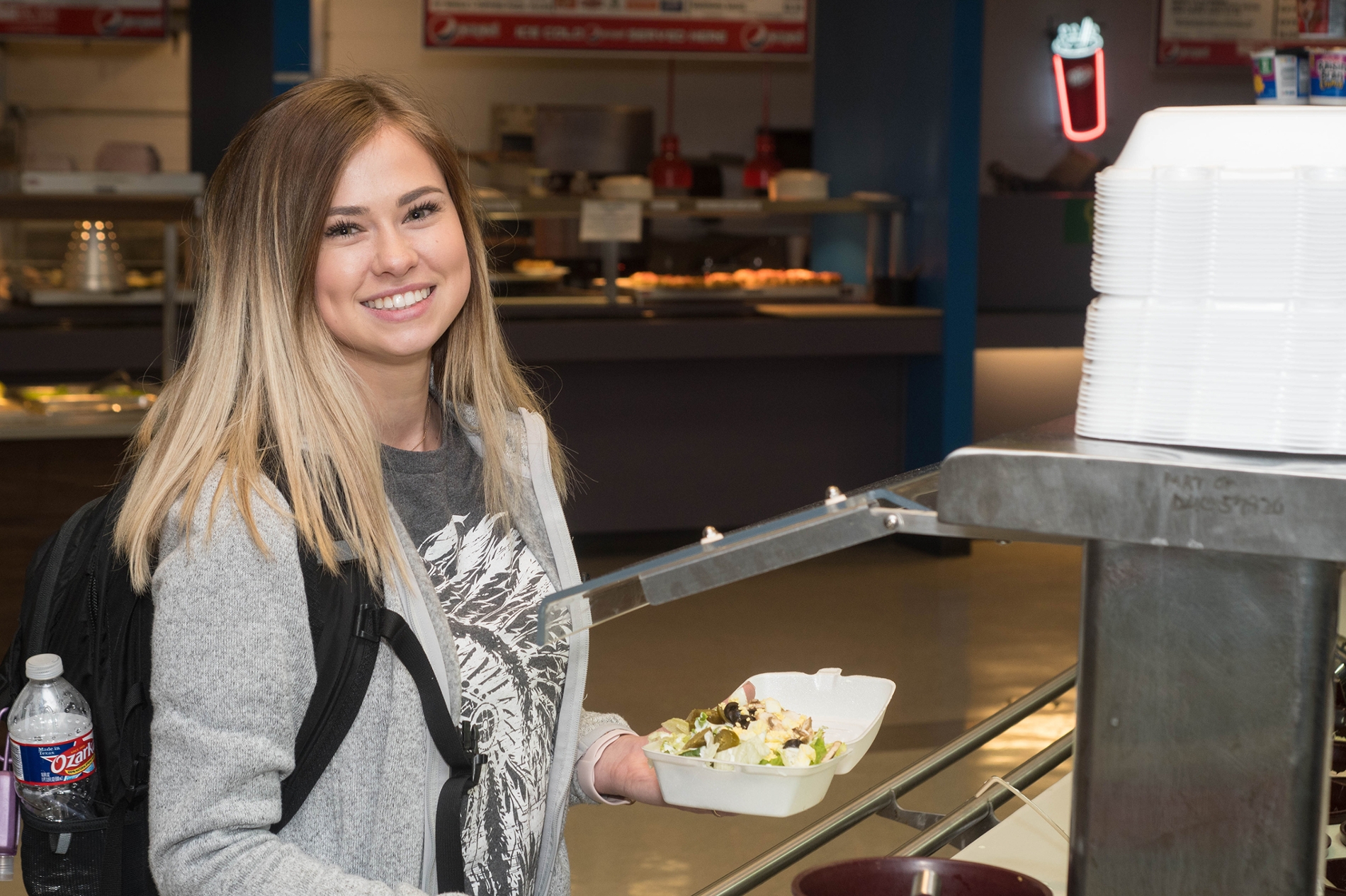 A student prepares a salad at the salad bar at Campus Dining in the Harvin Student Center