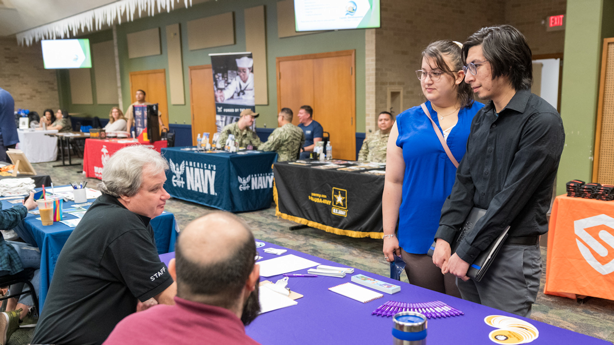 Recruiter discusses job postings with student at career fair