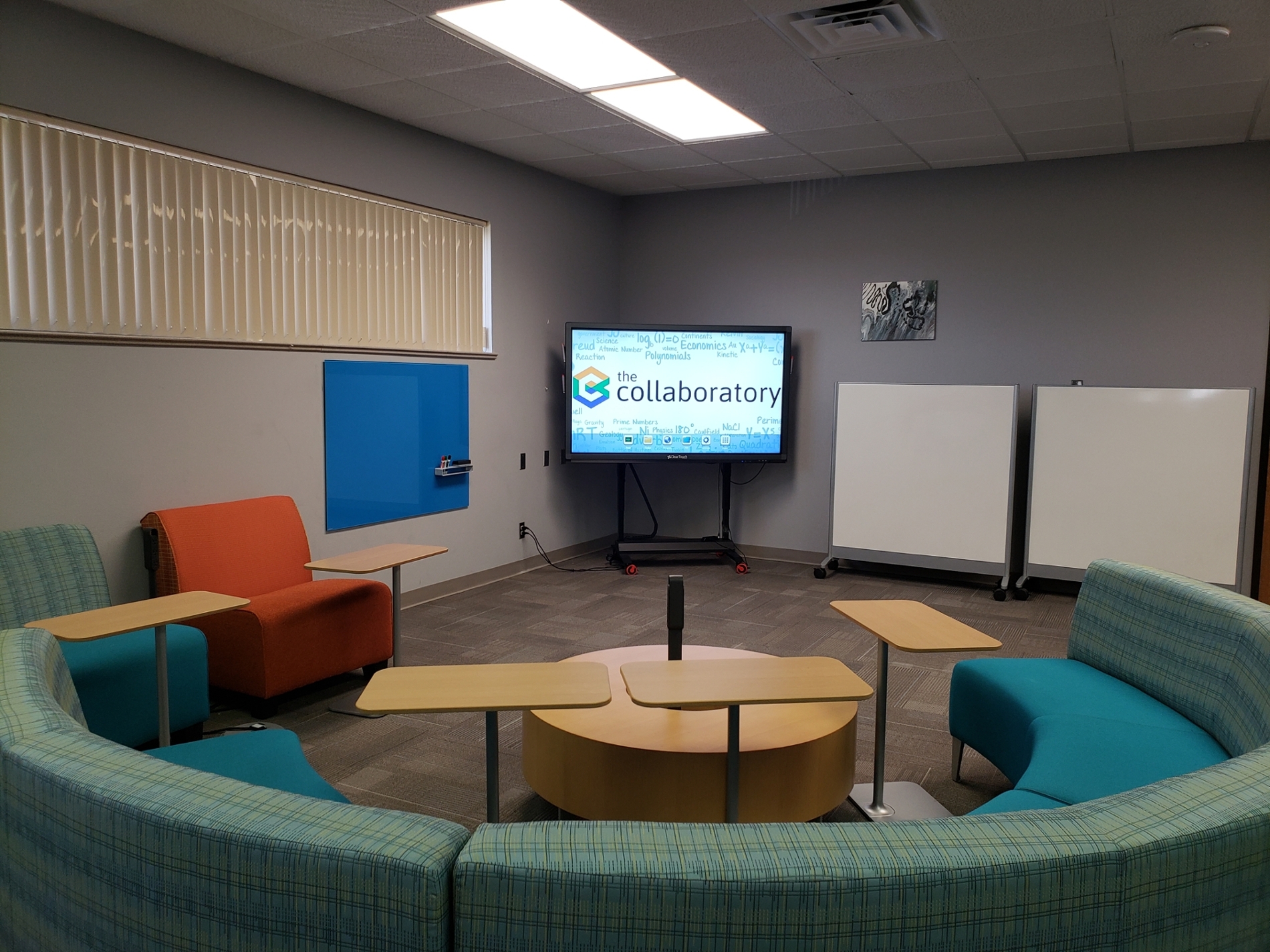 Corner of Collaboratory with sofa, whiteboards, and clear touch.