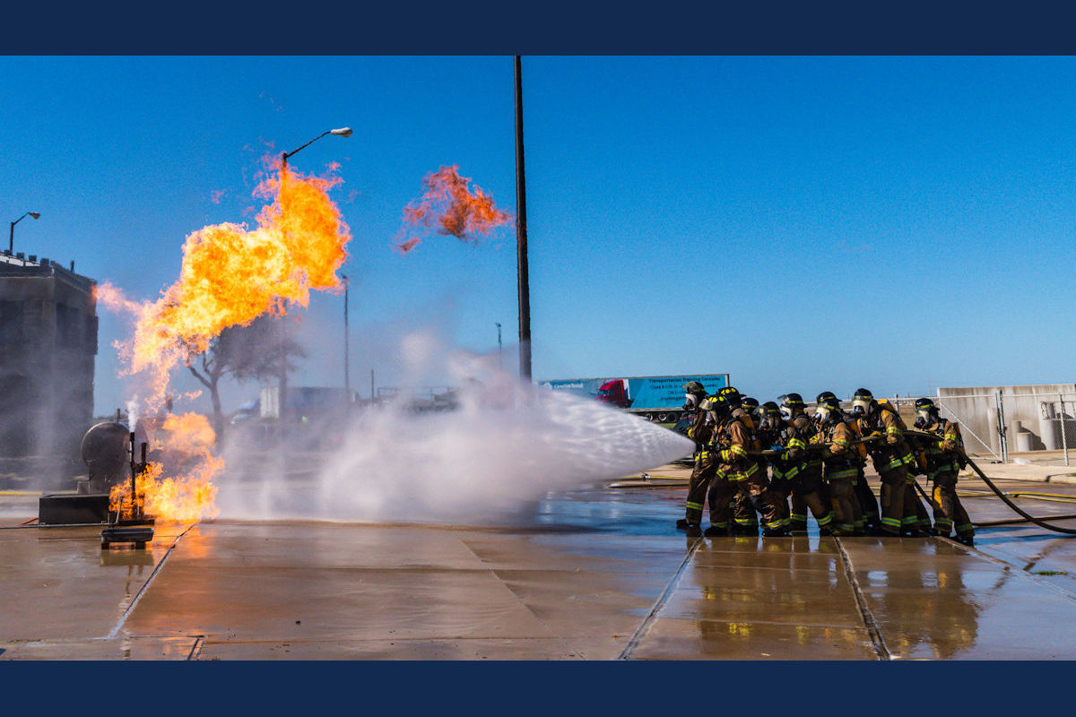 Firefighter students extinguishing a demonstration building fire