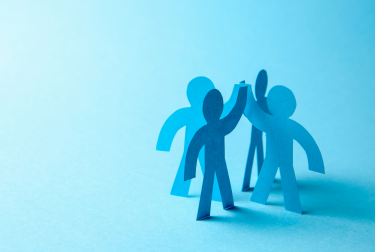 Four overlapping blue human silhouettes standing together against a turquoise background.
