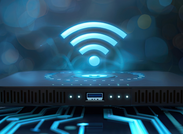 A router with a glowing blue Wi-Fi icon above it, set against a blurry, tech-themed background.
