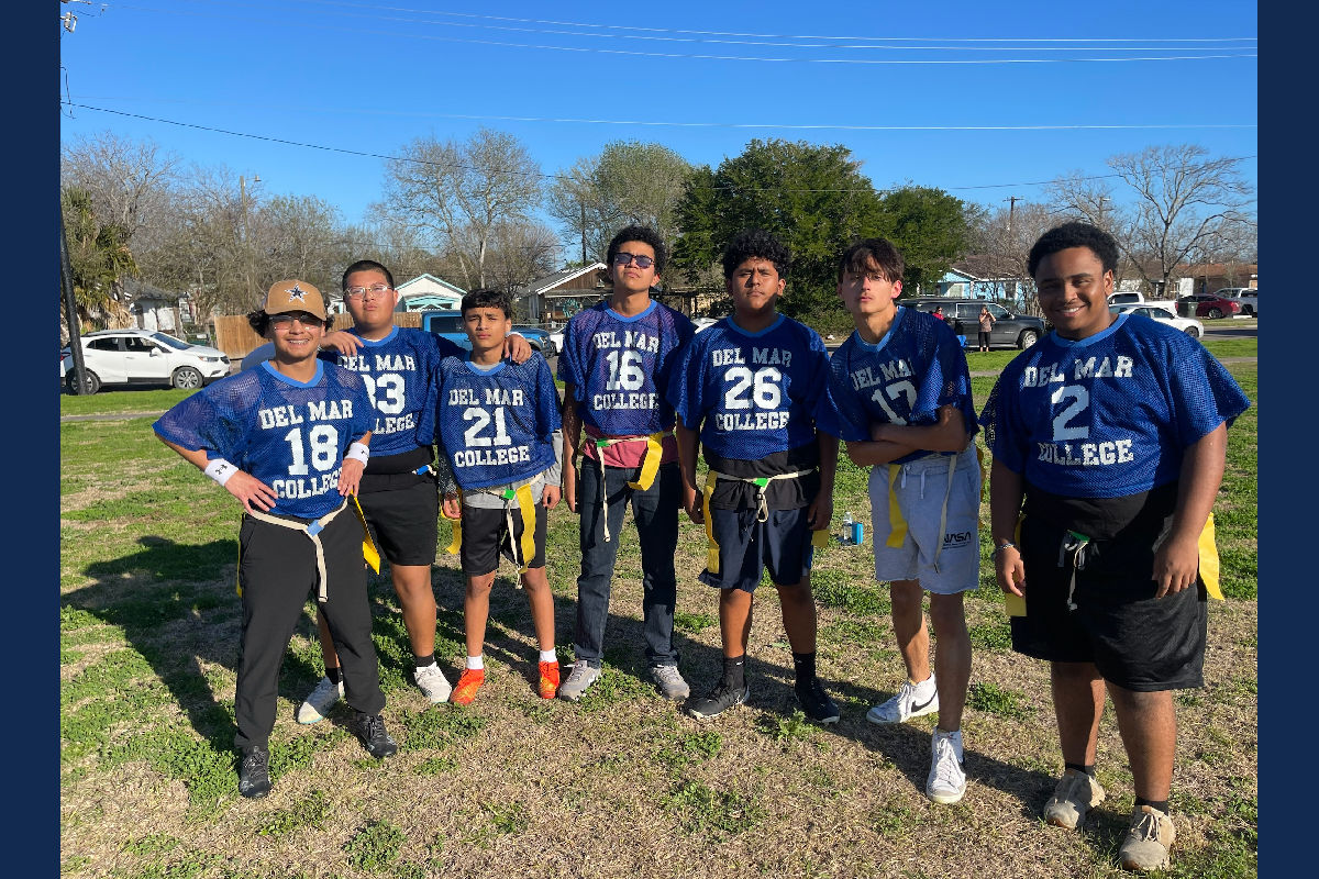 Group of students playing flag football pose for photo