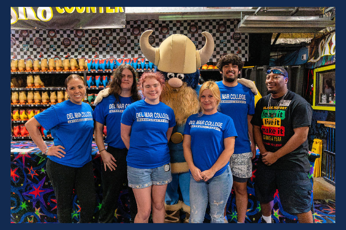 Students and instructors at skating party pose for photo with Valdar the Viking