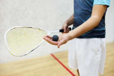 Guy holding a raquet and ball