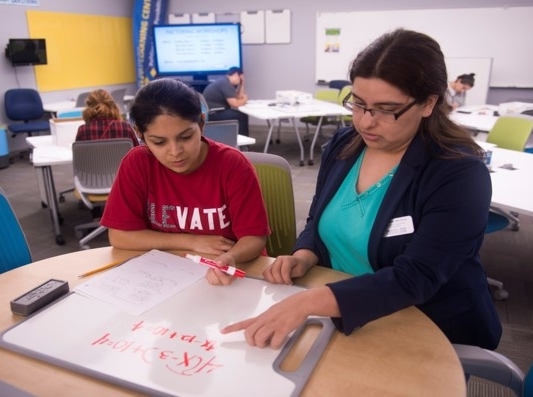 Tutor working with a student using a small whiteboard.