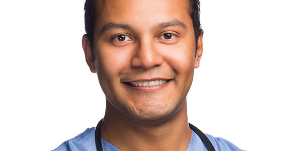 A male nursing student in scrubs