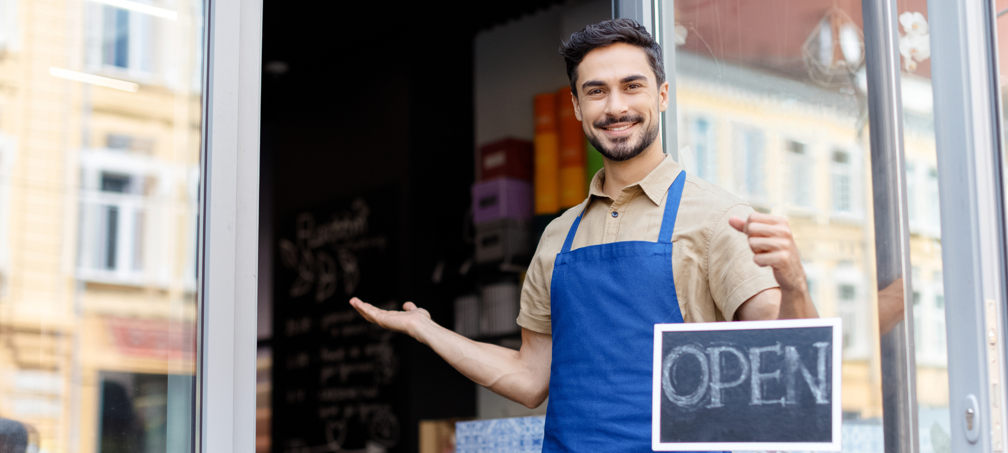 Business owner in front of an open sign